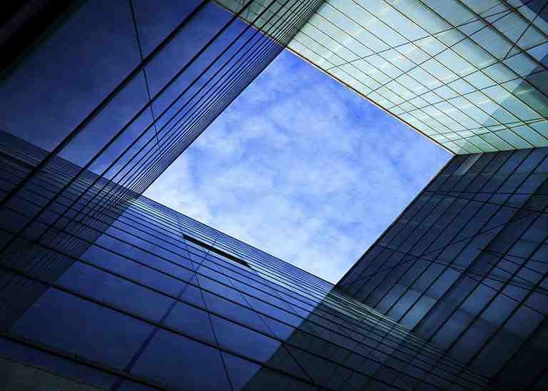 Blick auf blauen Himmel zwischen Glasgebäuden