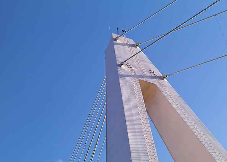 Skulpturhafter Brückenpfeiler von unten mit blauem Himmel
