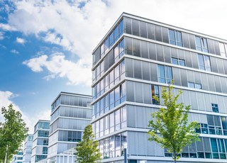 Bürogebaude bei blauem Himmel mit Wolken