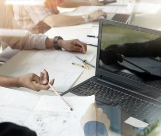 Bürotisch Arbeitsbild mit Unterlagen, Laptop und Händen