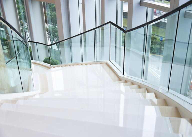 Moderne Treppe mit Glasgeländer sauber glänzend